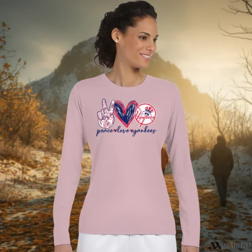 Peace Love New York Yankees Women’s Light Pink Long Sleeve – Female Model in White Office Female Model Wearing Peace Love New York Yankees Women's Light Pink Long Sleeve in a minimalist white office background. Styled with a casual long sleeve top.
